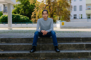 dark-haired male sitting on steps