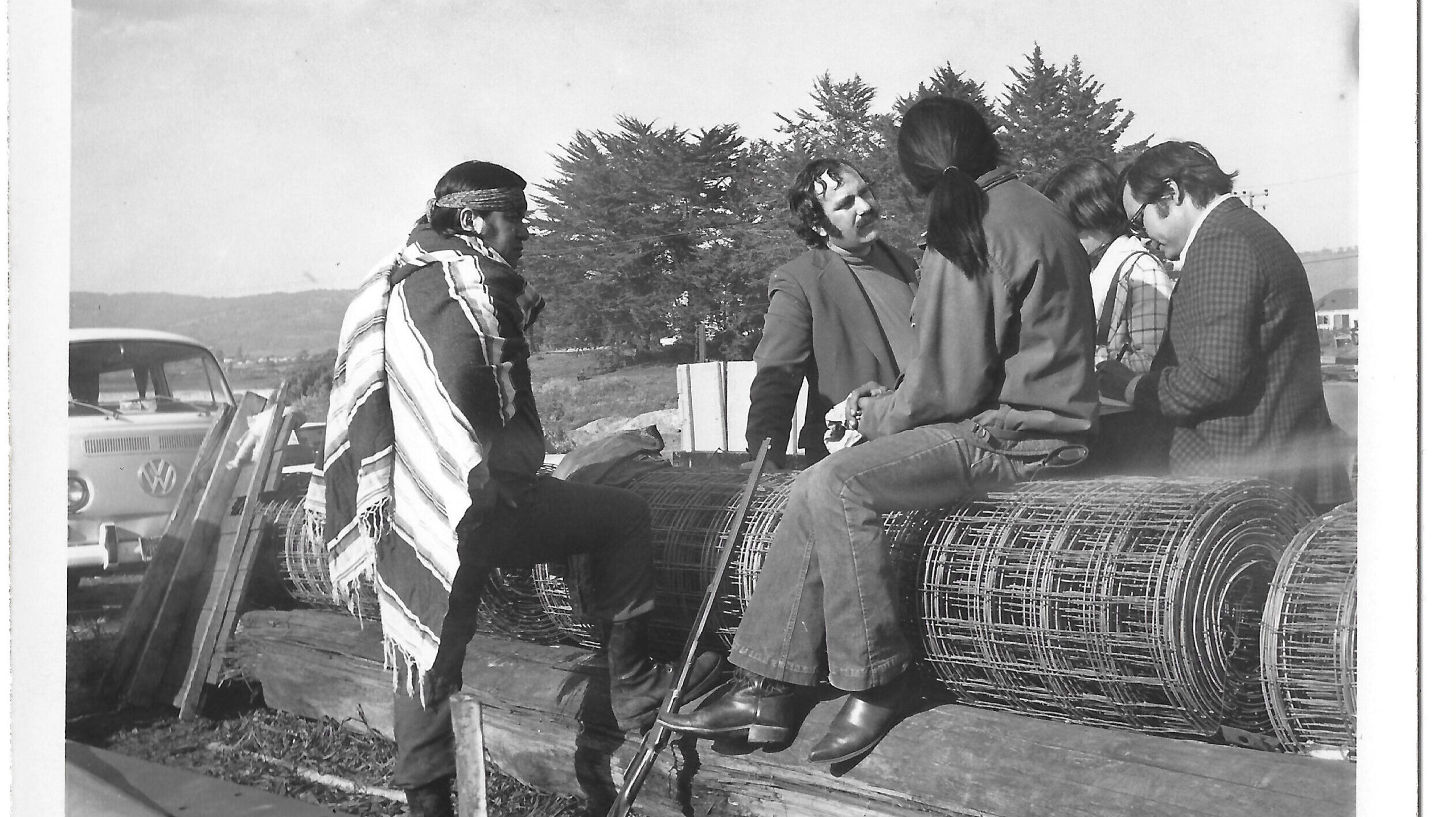 black and white image of three men sitting together