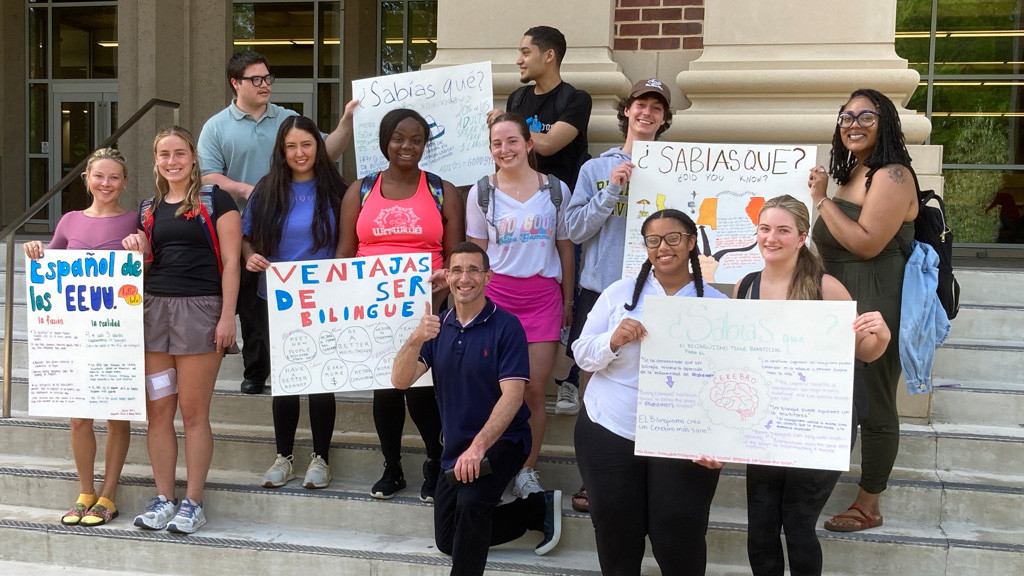 Students holding signs outside of a building