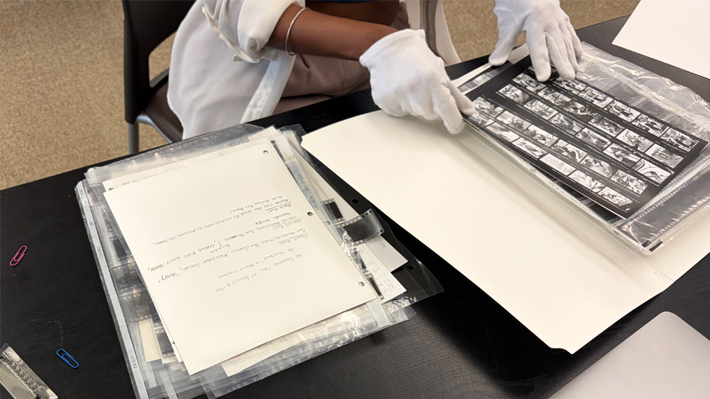 Person viewing photo negatives with white gloves