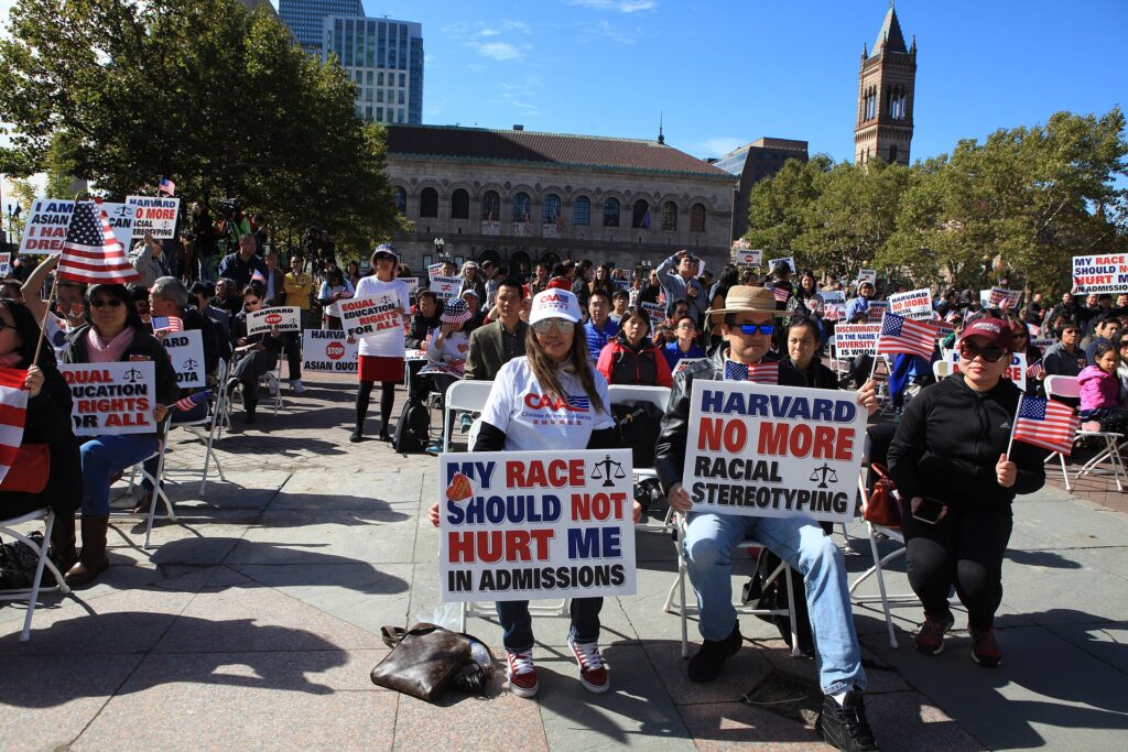 Image of a group of individuals from the Chinese American Alliance holding signs at a protest against affirmative action.