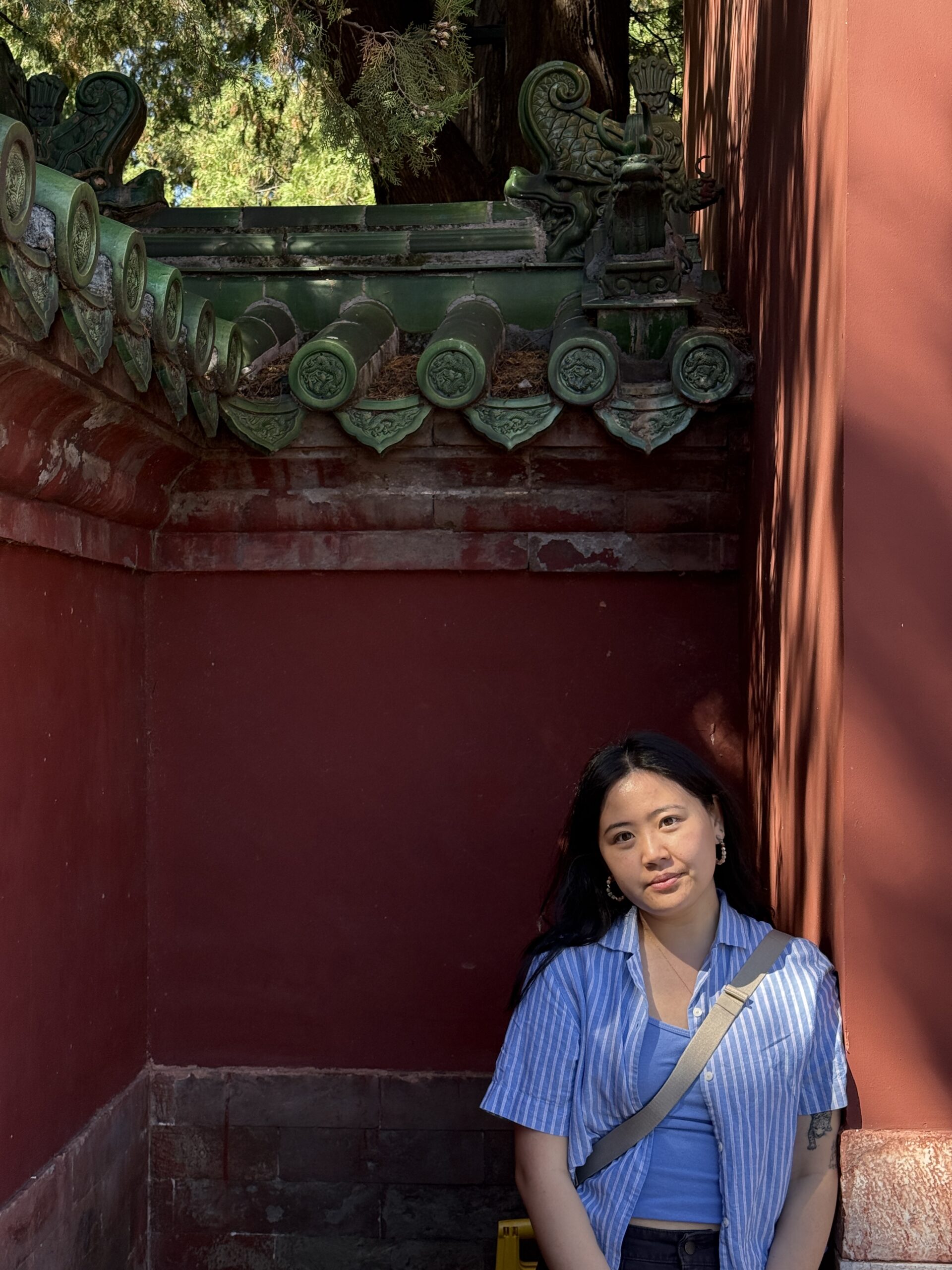 Image of Ja Bulsombut wearing a blue shirt leaning against a red wall