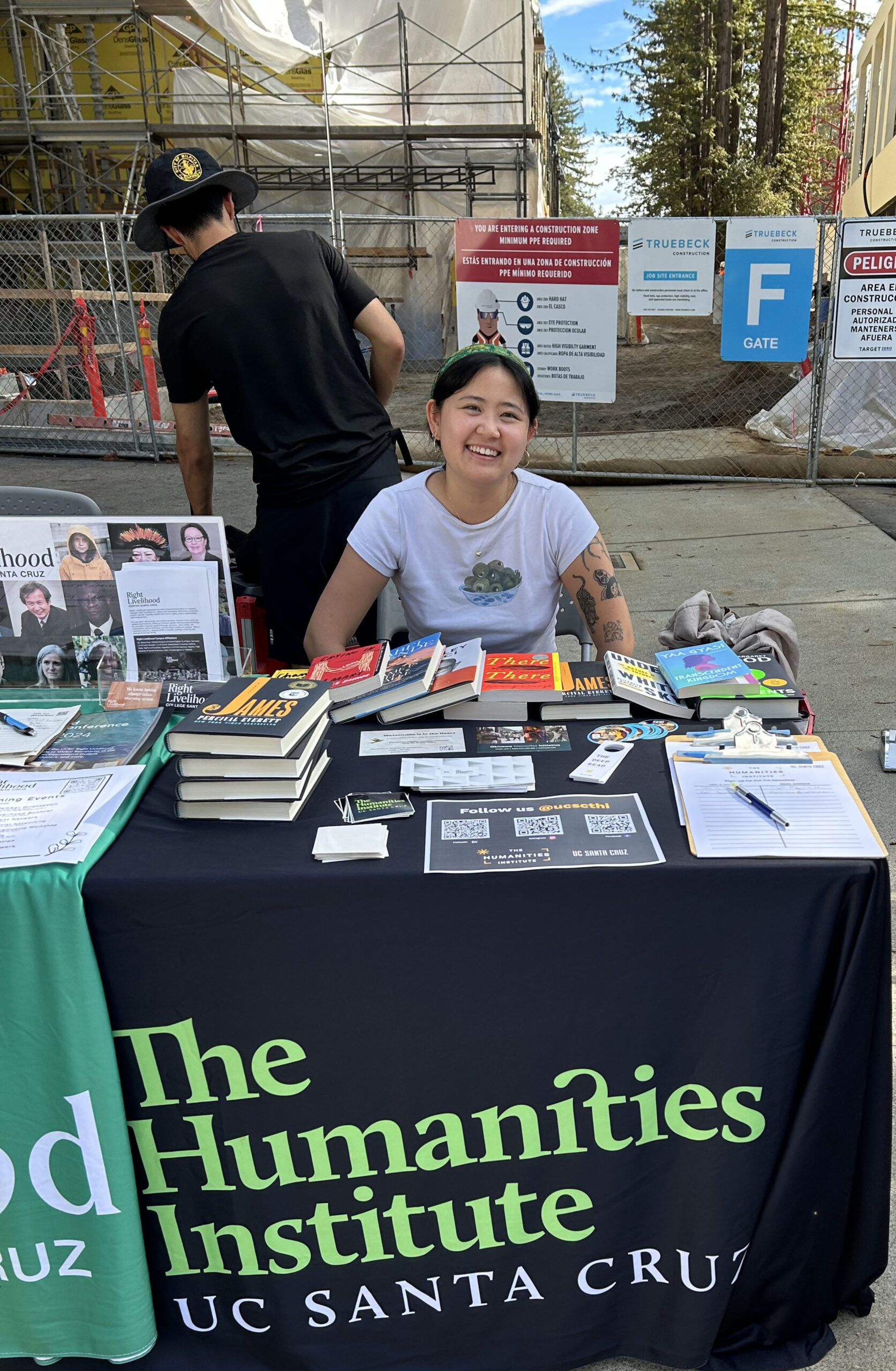 Ja tabling for THI on campus with construction in the background.